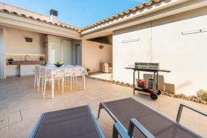 a patio with a table and chairs and a grill at Es Pop Nou in Sa Ràpita
