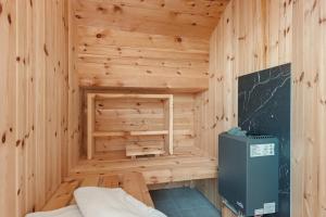 a wooden sauna with a refrigerator in a room at Prielerhof in San Lorenzo di Sebato