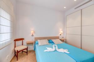 a bedroom with two white towels on a blue bed at Es Pop Nou in Sa Ràpita