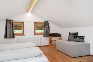 a attic bedroom with two beds and a couch at Prielerhof in San Lorenzo di Sebato