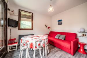 a living room with a red couch and a table at Fleury in Mieussy