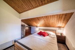 a bedroom with a bed with red pillows on it at Fleury in Mieussy