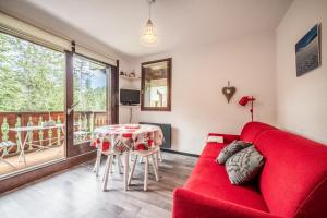 a living room with a red couch and a table at Fleury in Mieussy