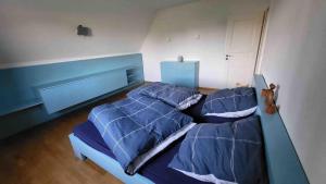a bedroom with a bed with blue comforter at Sommerlich bei den Sorben in Schmerlitz