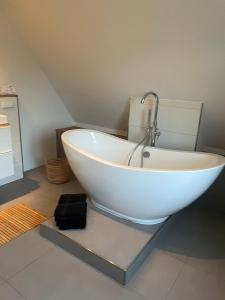 a white bathtub with a faucet in a bathroom at Sommerlich bei den Sorben in Schmerlitz
