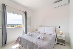 ein Schlafzimmer mit einem großen Bett, auf dem Handtücher liegen in der Unterkunft Rozario in Alepou