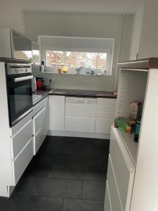 a kitchen with white cabinets and a window at Sommerlich bei den Sorben in Schmerlitz