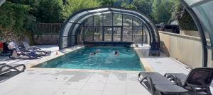 two people swimming in a swimming pool in a building at T2 avec piscine couverte et parking in Saint-Lary-Soulan