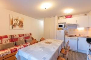a room with a table and a kitchen and a table and a kitchen at T2 avec piscine couverte et parking in Saint-Lary-Soulan