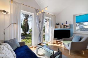 a living room with a blue couch and a tv at Ferienhaus Gerster in Mitten