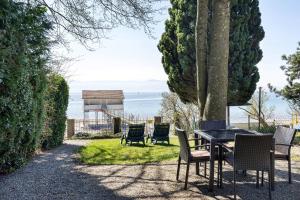 a table and chairs with a view of the ocean at Ferienhaus Gerster in Mitten