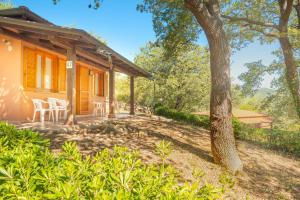 a wooden house with chairs and a tree at Villaggio Colombo V3 comfort in Marina di Andora