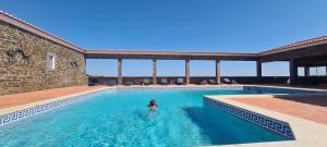 a woman standing in the water in a swimming pool at Casas do Monte I in Giões