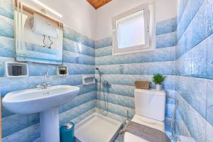 a blue tiled bathroom with a sink and a toilet at Dolphin villa 2 in Gaios +26 photos
