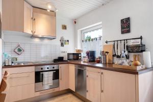 a kitchen with wooden cabinets and a counter top at Ferienwohnung am Schwellenweiher in Feldberg