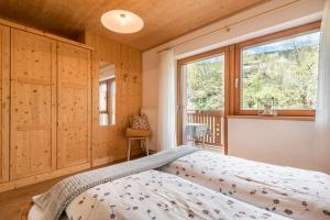 a bedroom with a bed and a window at Huberhof App Rubens in Feldthurns +21 photos