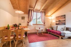 a living room with a red couch and a table at Huberhof App Rubens in Feldthurns