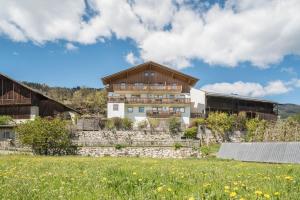 a house on top of a hill with a field at Huberhof App Rubens in Feldthurns