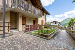a house with a balcony and a stone walkway at Casa Valentina in Ledro