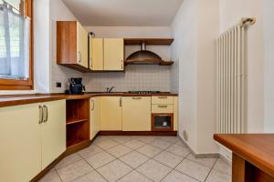 a kitchen with yellow cabinets and a stove at Casa Valentina in Ledro