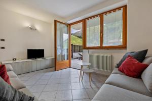 a living room with a couch and a tv at Casa Valentina in Ledro