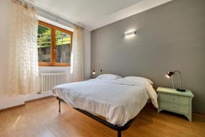 a bedroom with a large bed and a window at Casa Valentina in Ledro