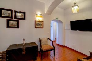 a room with a chair and a flat screen tv at Villa Oliva Al ii in Moncarapacho