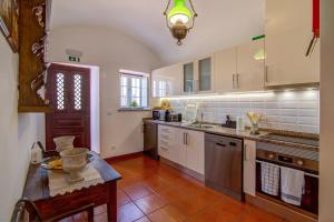 a large kitchen with white cabinets and a table at Villa Oliva Al ii in Moncarapacho