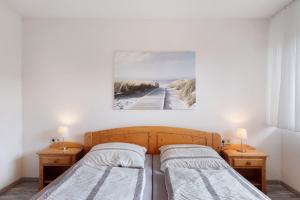 a bedroom with two beds and a painting on the wall at Haus Reiser in Alpirsbach
