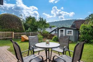 a patio with a table and chairs in a yard at Haus Reiser in Alpirsbach