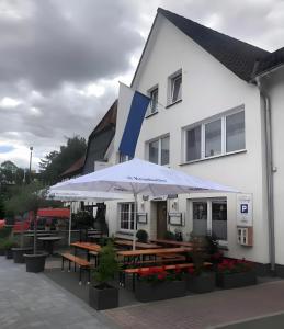 a building with tables and umbrellas in front of it at Apartment Ballova in Balve