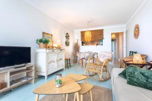 a living room with a couch and a tv at La Houle, appartement face mer in Les Sables-d'Olonne