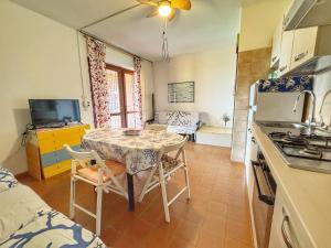 a kitchen with a table and chairs in a room at Casa 3 Punta Negra in Stintino