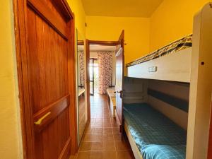 a small room with two bunk beds and a hallway at Casa 3 Punta Negra in Stintino