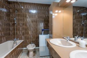 a bathroom with a sink and a tub and a toilet at La Houle, appartement face mer in Les Sables-d'Olonne +12 photos