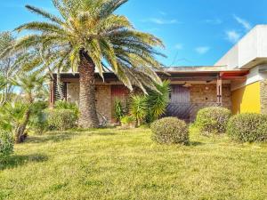 a palm tree in front of a house at Casa 3 Punta Negra in Stintino