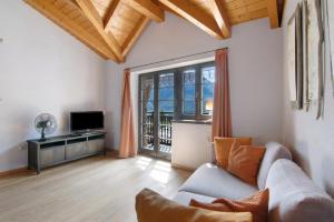 a living room with a couch and a television at Casa Pollicina in Margno