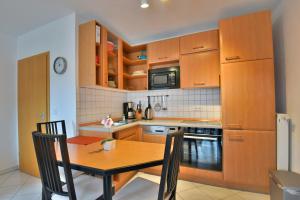 a kitchen with wooden cabinets and a wooden table with chairs at Ferienwohnung Tannenblick 3-3 in Oberhof