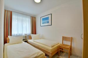 a hotel room with two beds and a chair at Ferienwohnung Tannenblick 3-3 in Oberhof