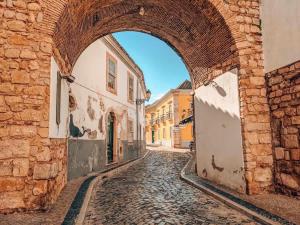 an alley in an old town with an archway at Formosa Home in Faro