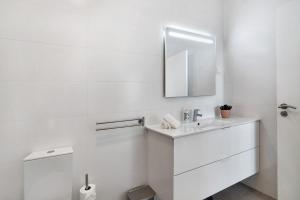a white bathroom with a sink and a mirror at Formosa Home in Faro +20 photos
