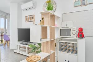a living room with white cabinets and a tv at Estudio El Faro 2 in Torrox