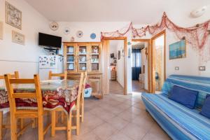 a living room with a dining room table and a bedroom at Adriana's house in Buggerru