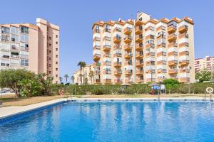 a hotel with a swimming pool in front of a building at Estudio El Faro 2 in Torrox