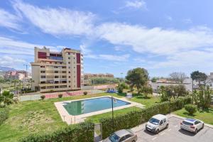a swimming pool in a parking lot next to a building at Estudio El Faro 2 in Torrox