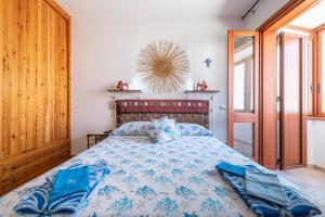 a bedroom with a bed with a blue comforter at Adriana's house in Buggerru