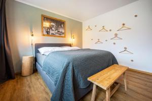 a bedroom with a bed with a blue blanket and a wooden table at Valentin36 Apartment Raschötz in Funes