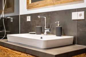 a bathroom sink with two soap dispensers on it at Valentin36 Apartment Raschötz in Funes