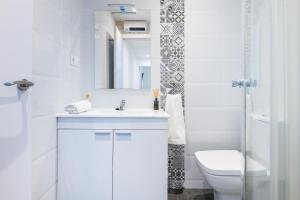 a white bathroom with a sink and a toilet at Apartamento Coral in Vinarós +19 photos
