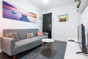 a living room with a couch and a tv at Apartamento Coral in Vinarós